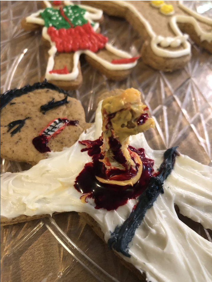a gingerbread man with an alien bursting from its chest
