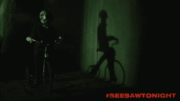 GIF of the scary doll riding a tricycle in the dark