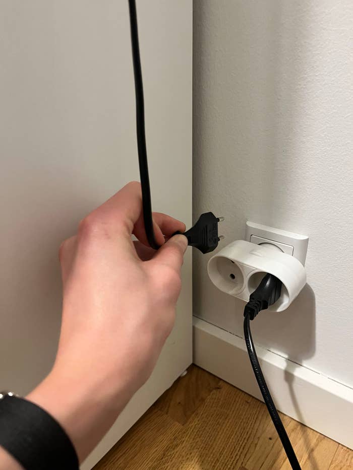 A person trying to plug in a wire