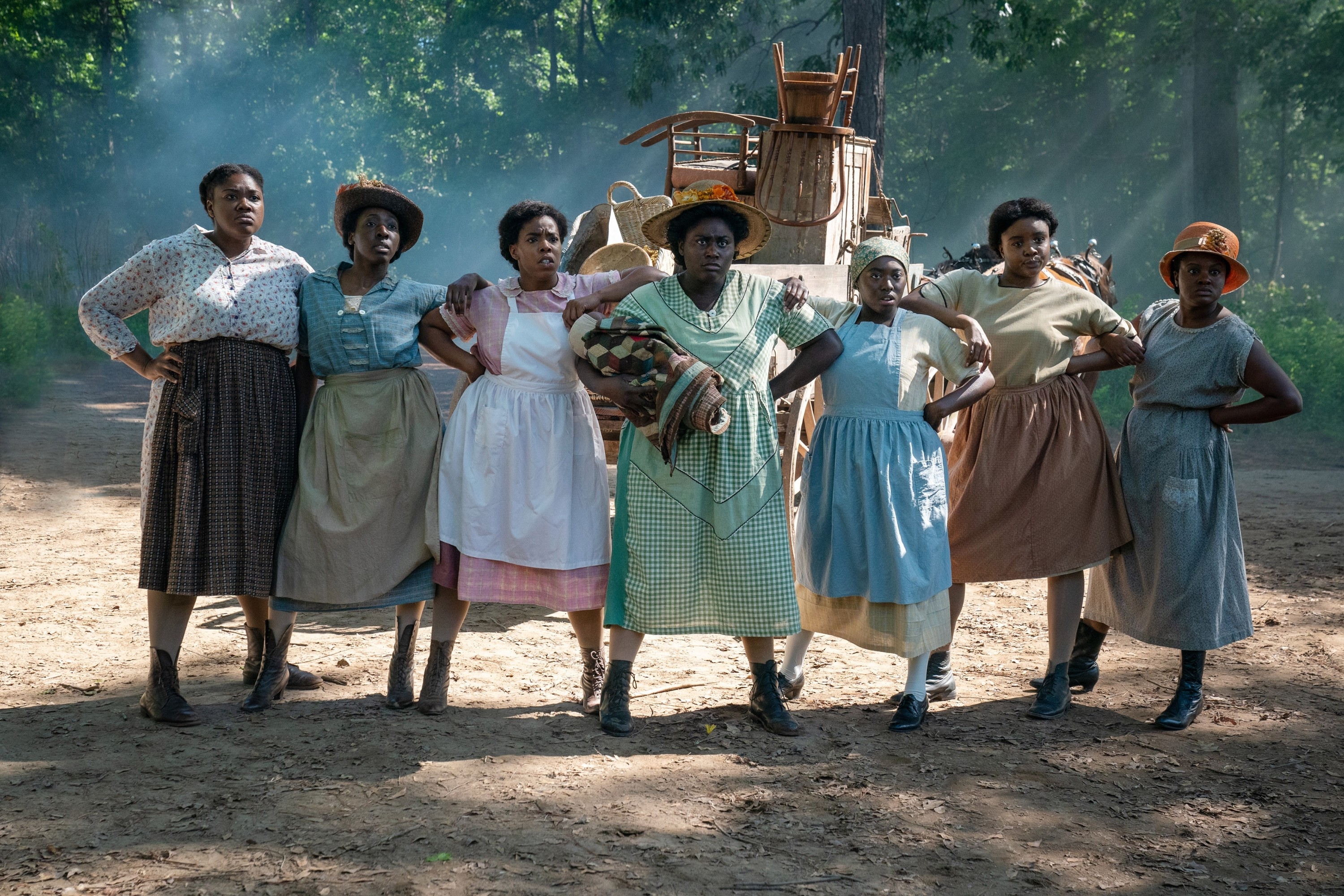 line of women linking arms on a dirt road