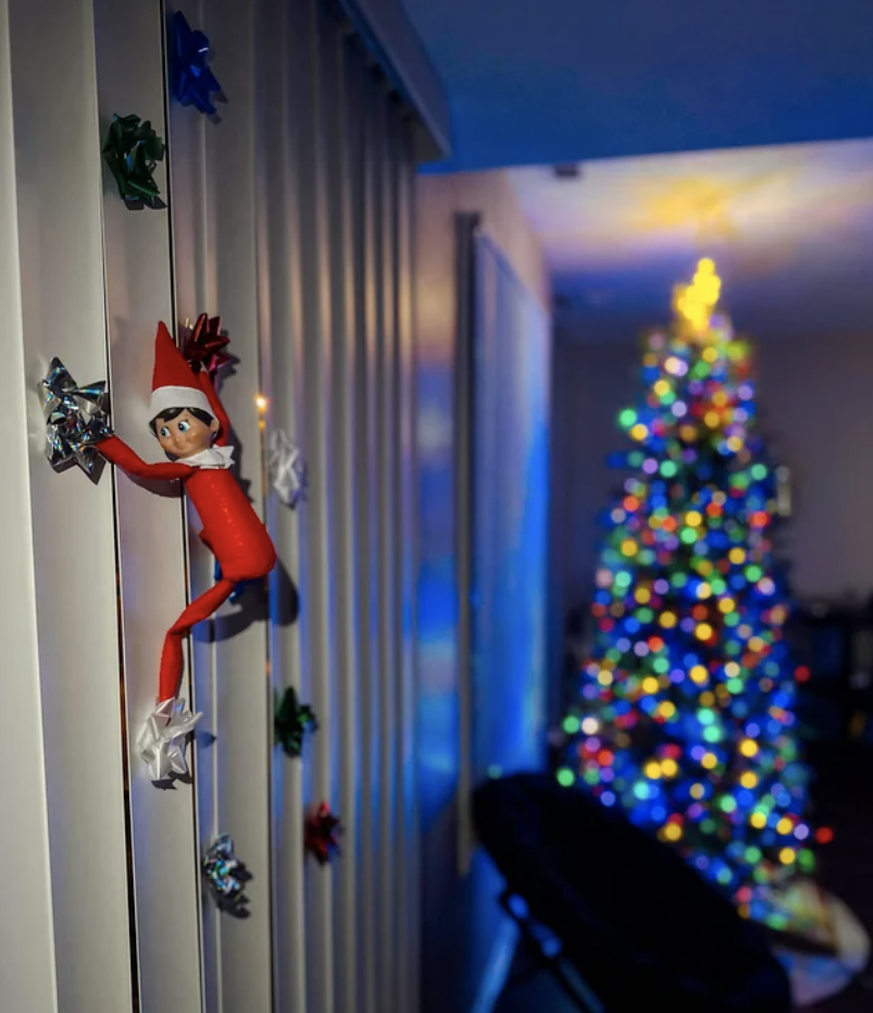 An Elf on the Shelf climbing up a wall