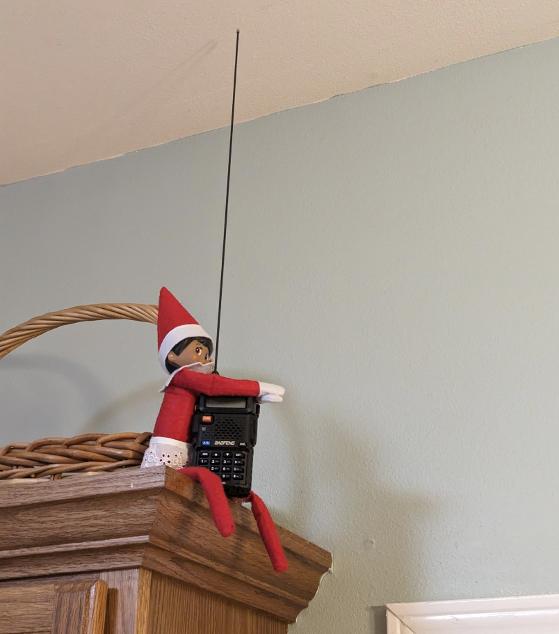 An Elf on the Shelf with a walkie-talkie