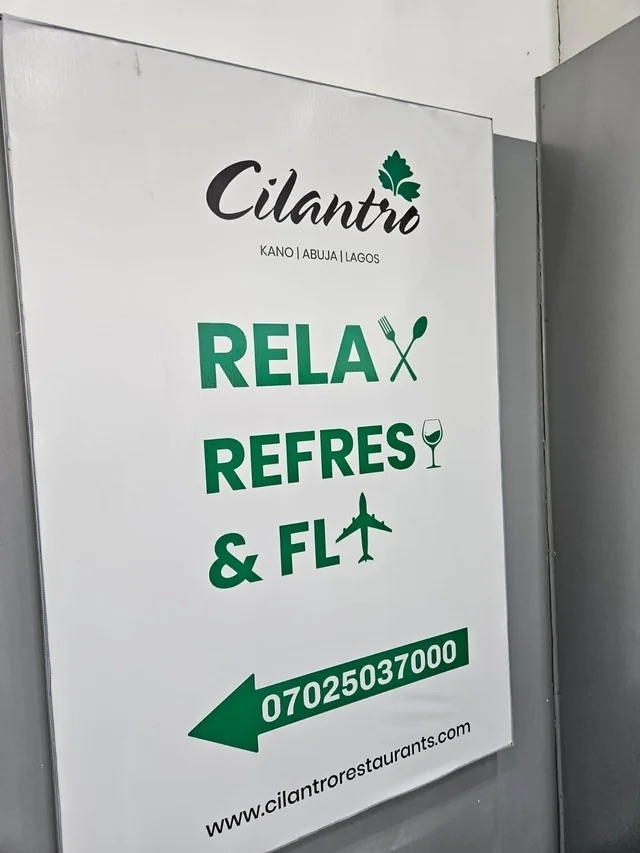 an airport sign that replaces the last letters in relax, refresh, and fly with icons