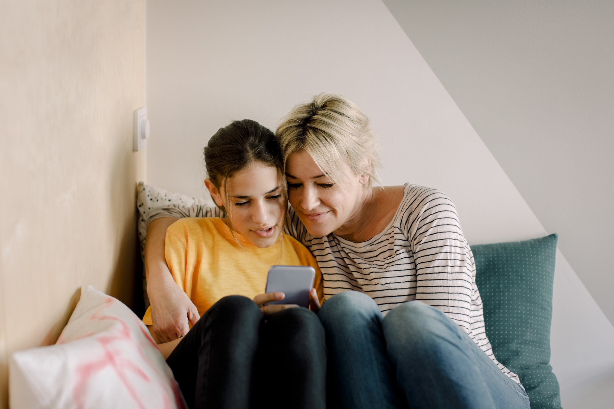 A daughter and mom are looking at a phone