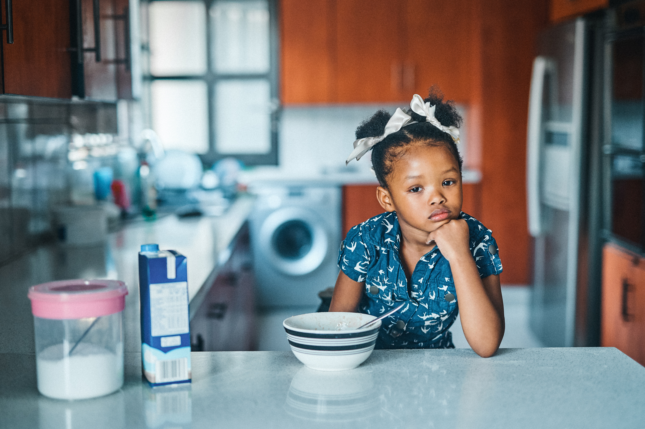 A young girl is sitting at the countertop