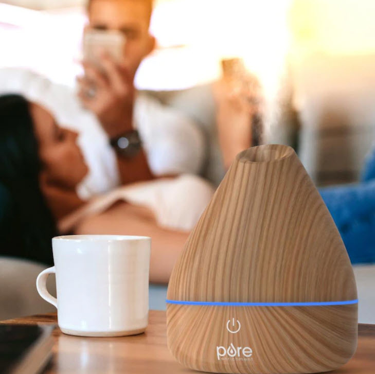 small pure brown diffuser being used next to white mug