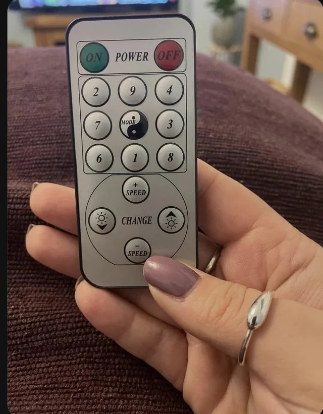 someone holding a remote with the numbers 1-9 in a random order