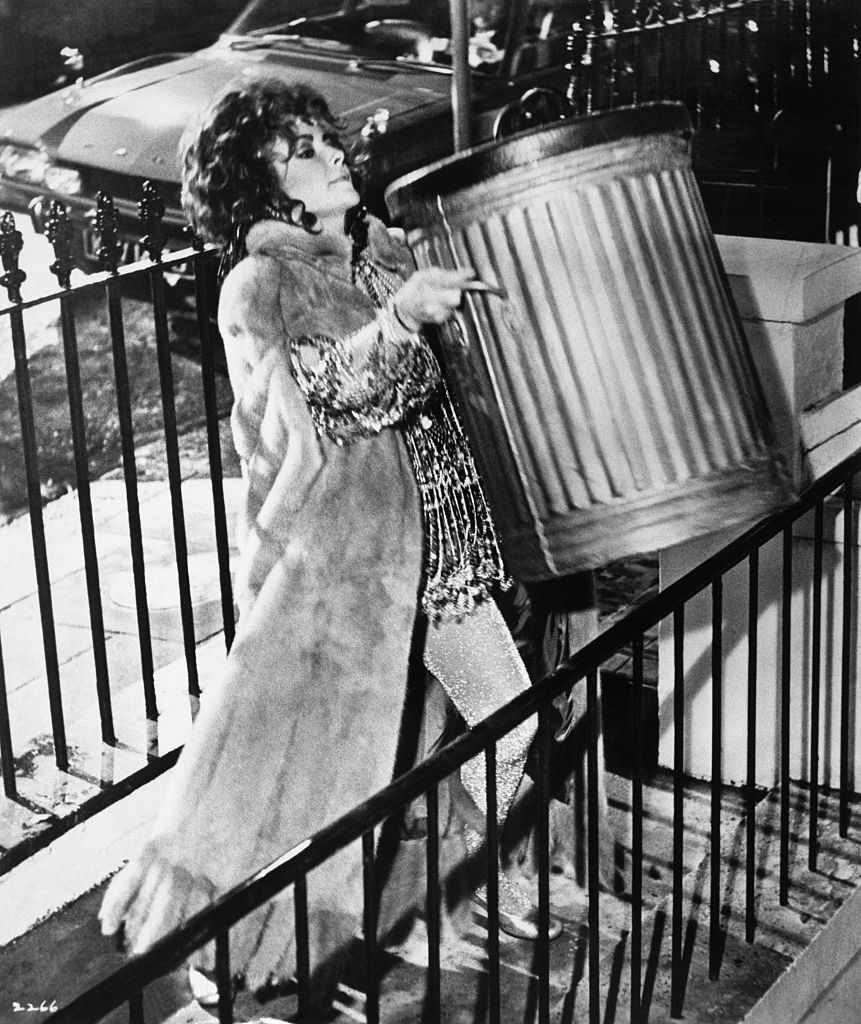 a woman lifting a garbage can