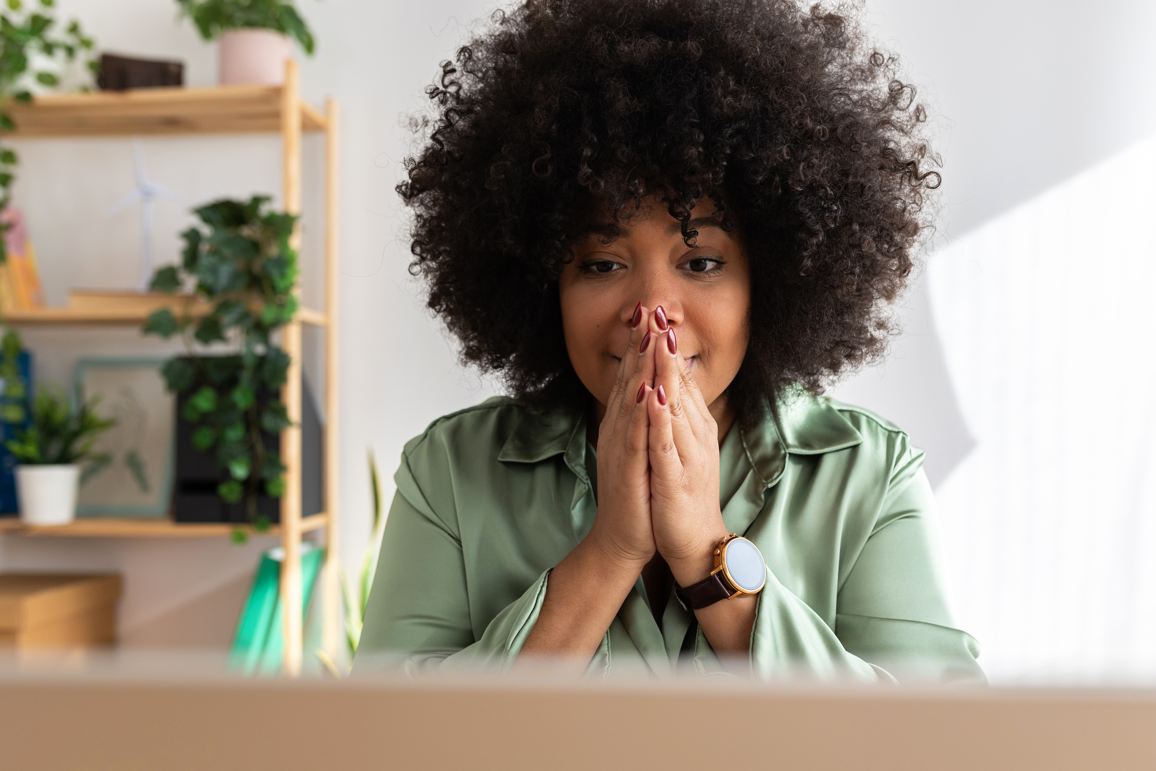 A woman praying at her desk