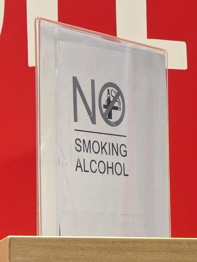 a sign that reads &quot;no&quot; with a line underneath and &quot;smoking alcohol&quot;