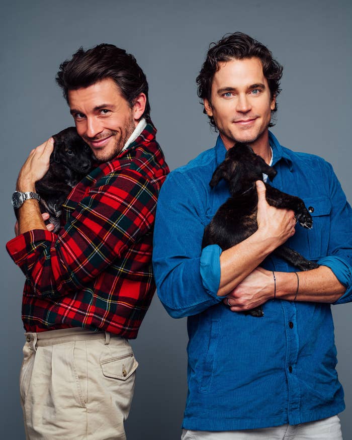 Close-up of Jonathan and Matt smiling and holding puppies
