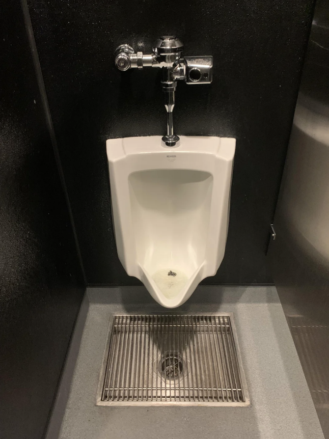 a grate below a urinal