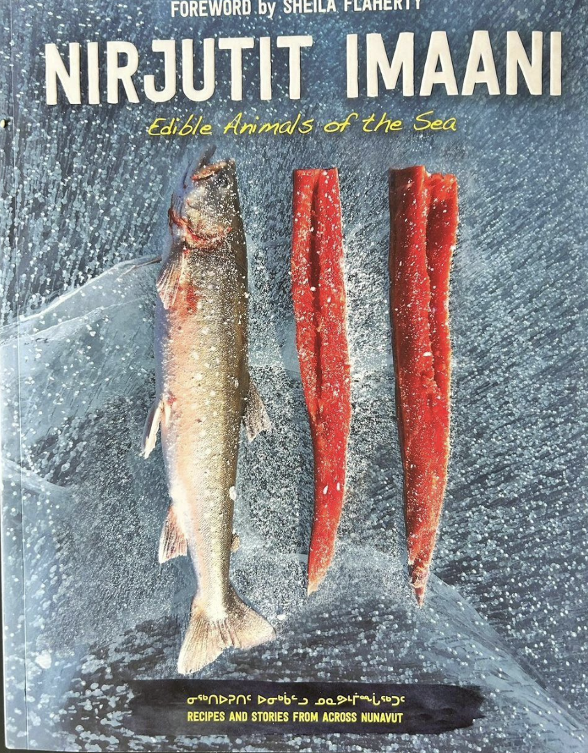 A book cover displays a fish and then fish meat. The title is &quot;Nirjutit Imaani: Edible Animals of the Sea.&quot;