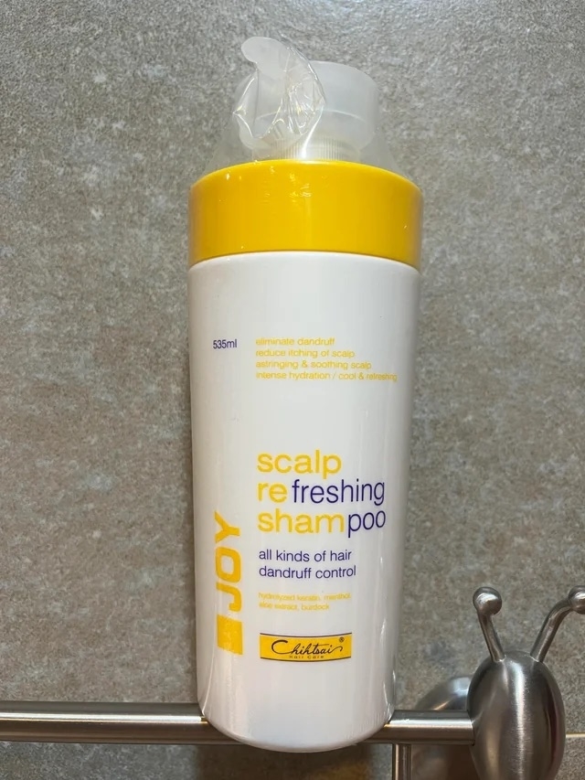 a shampoo bottle that reads &quot;scalp refreshing shampoo&quot; with &quot;scalp re sham&quot; written in yellow and &quot;freshing poo&quot; written in blue