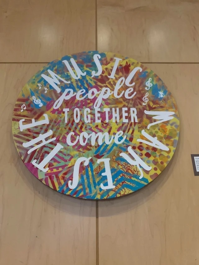 a circular sign with the words &quot;music makes the&quot; around the perimeter and &quot;people together come&quot; in the center