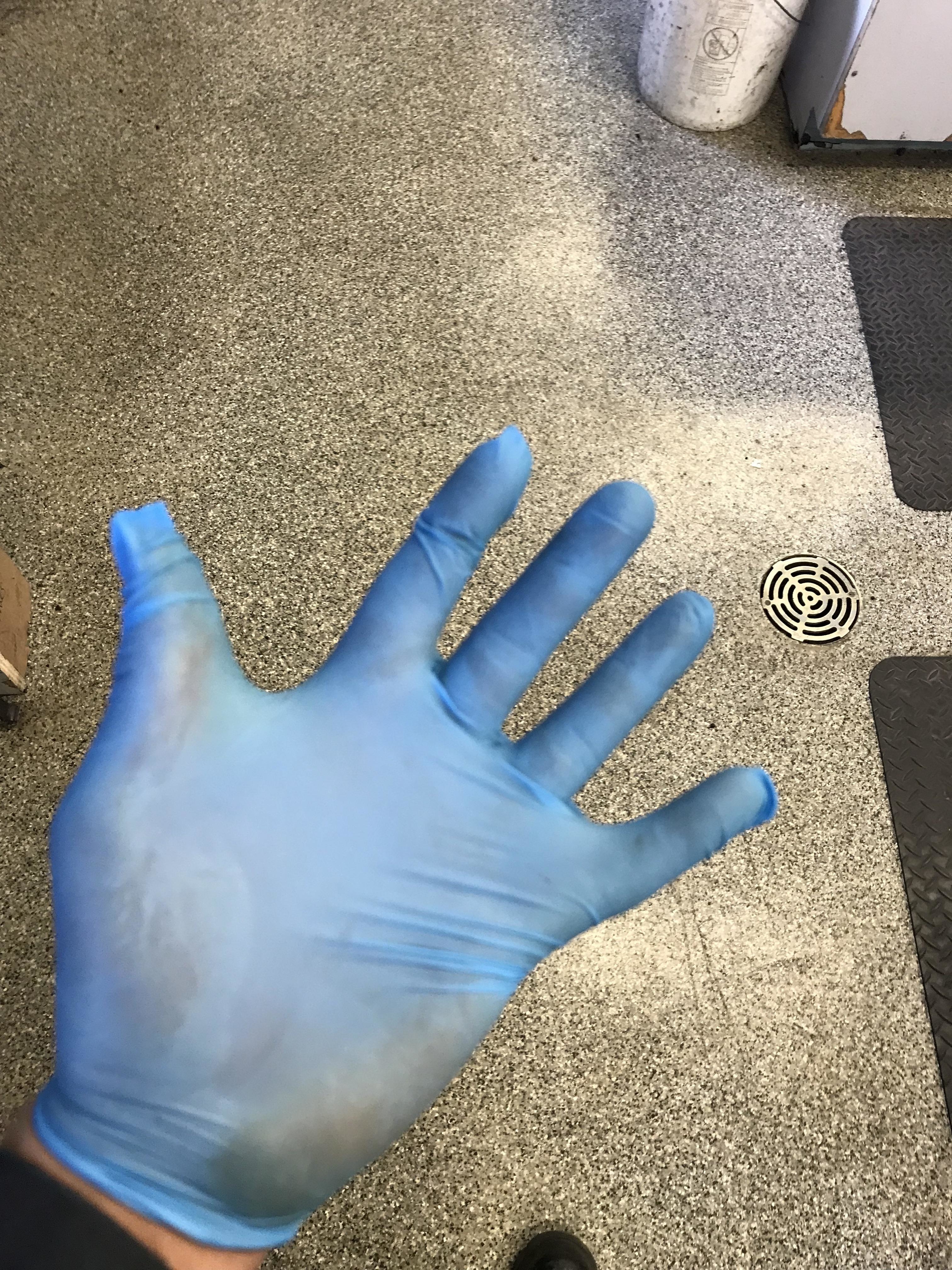 An employee wearing rubber gloves that are clearly too small