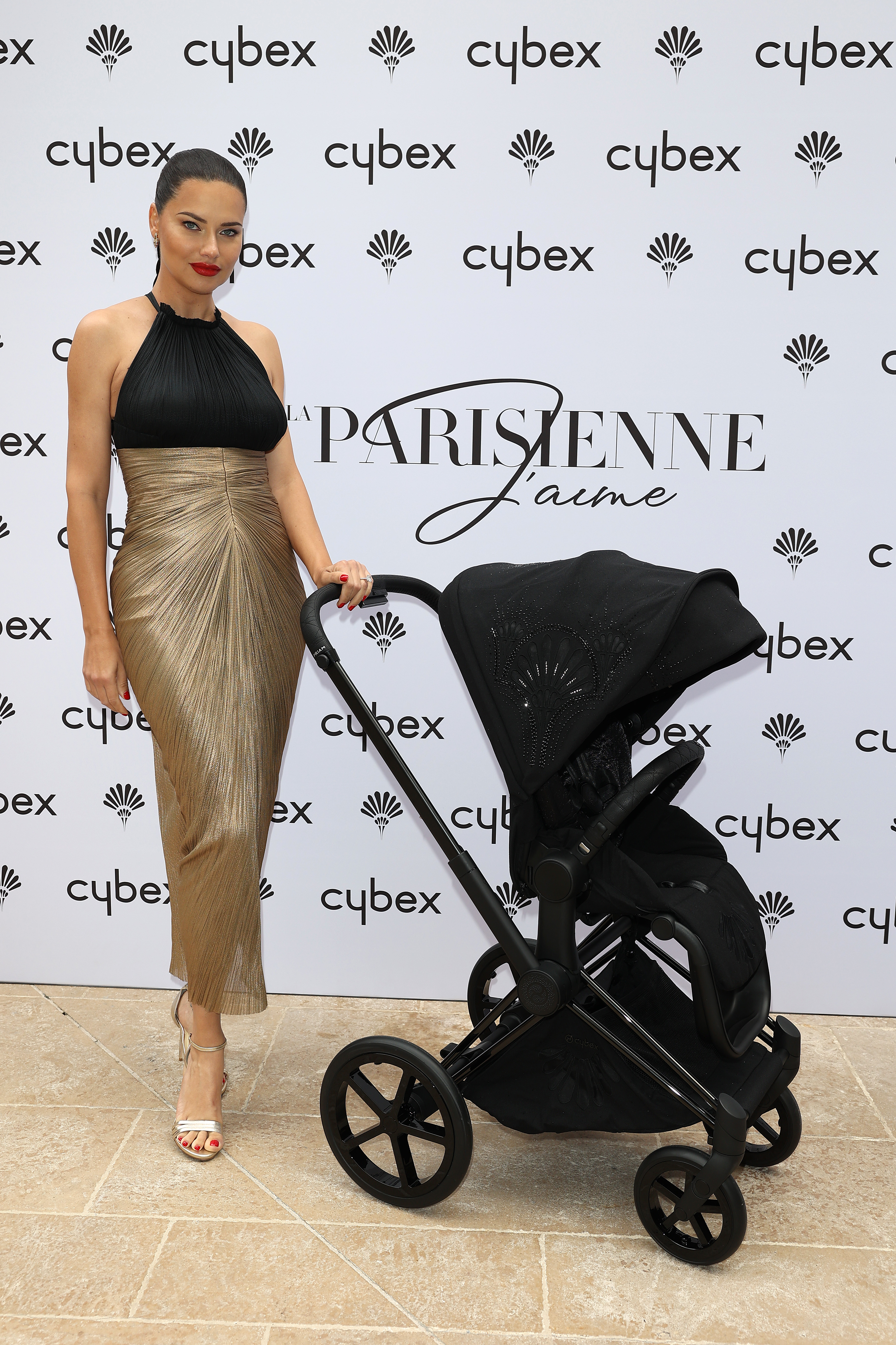 Adriana poses at an event with her baby stroller