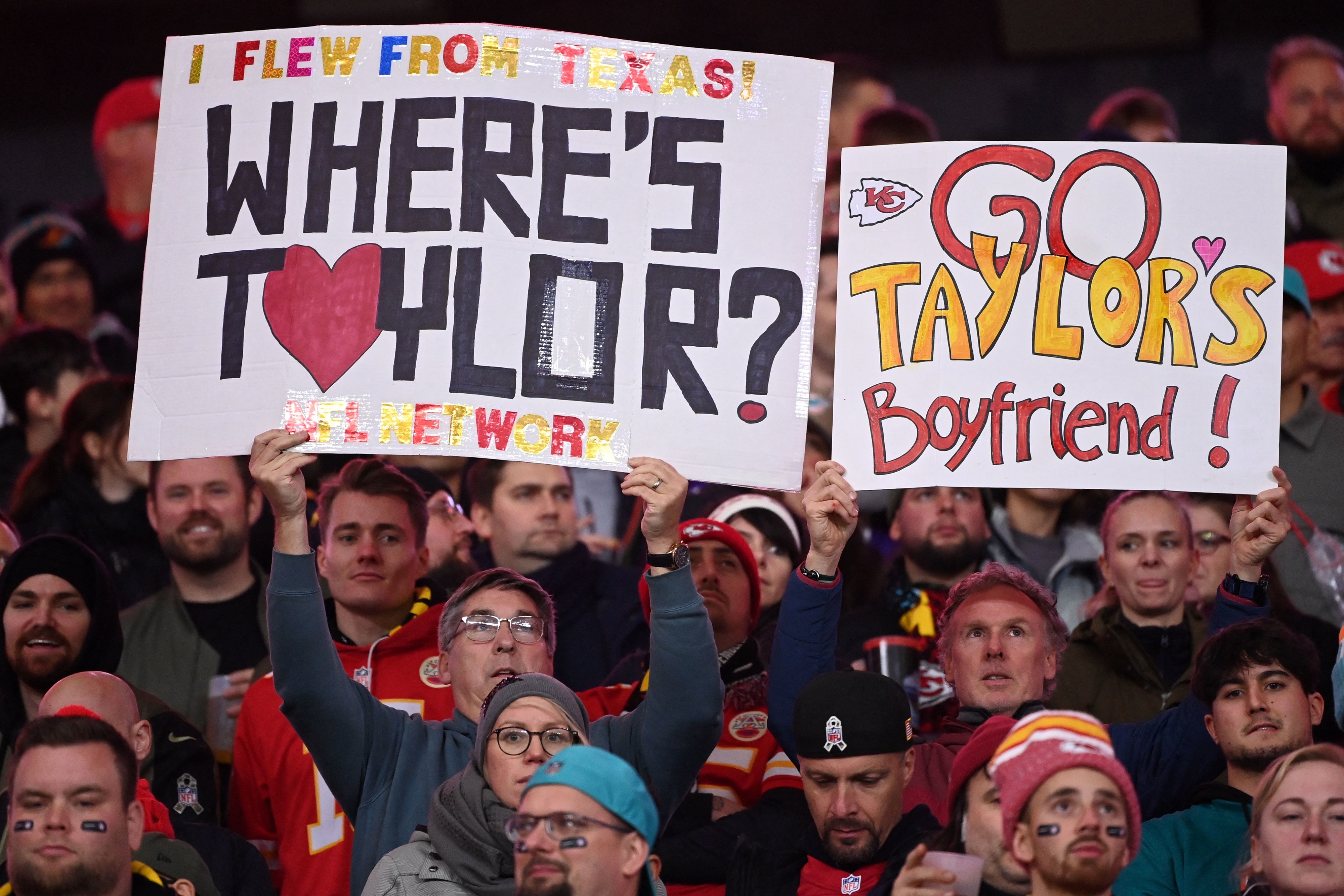 Fans holding up signs — &quot;Where&#x27;s Taylor?&quot; and &quot;Go Taylor&#x27;s boyfriend!&quot; — in the crowd