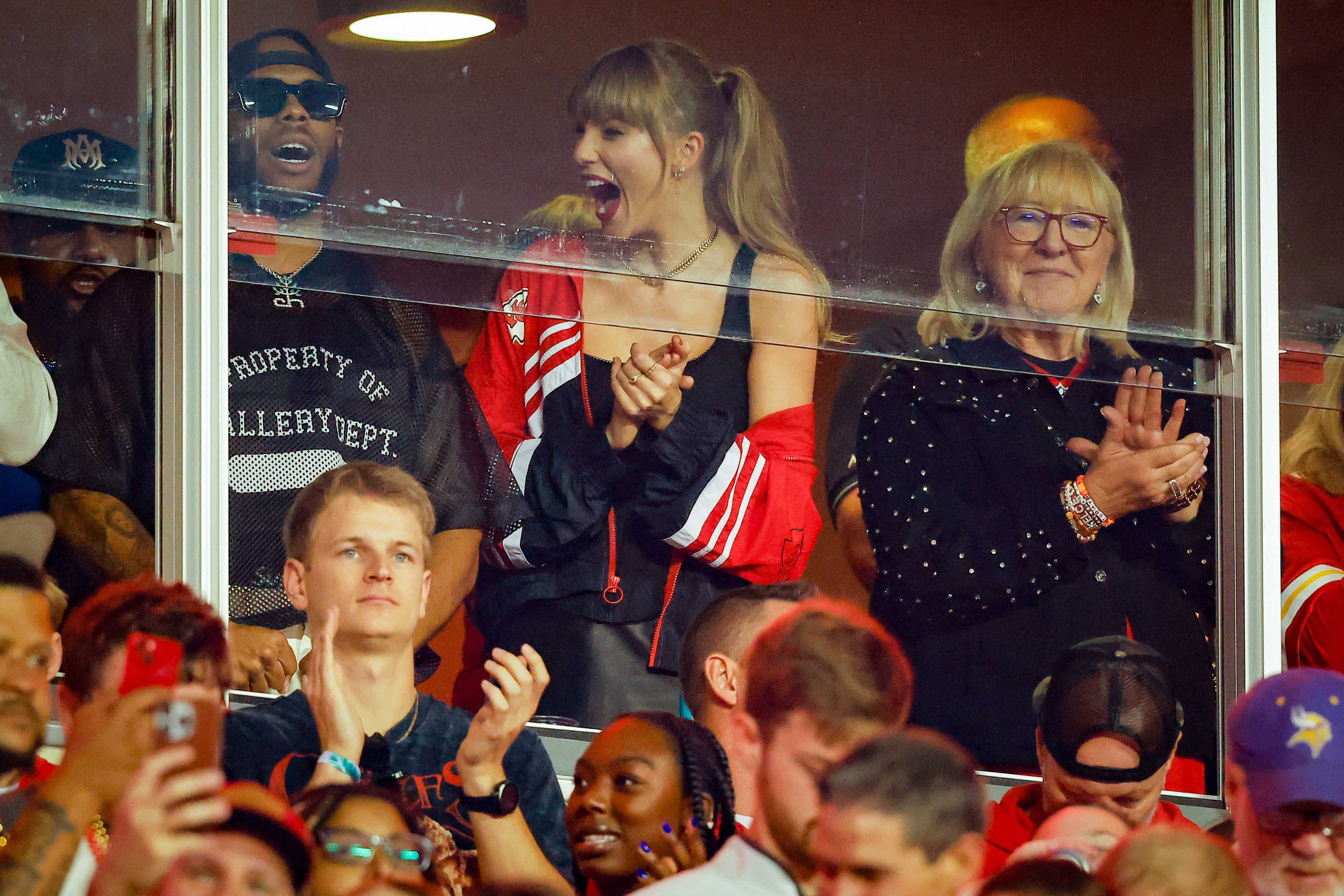Taylor celebrating with others in a VIP suite