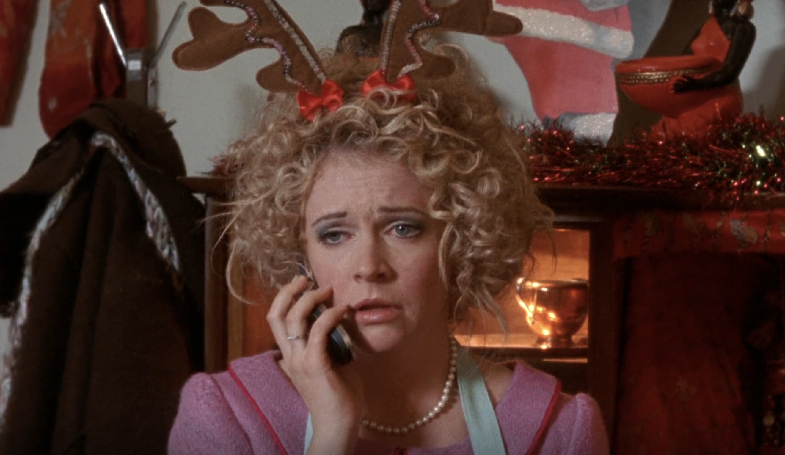Melissa Joan Hart in a pink dress as a diner while wearing reindeer ears