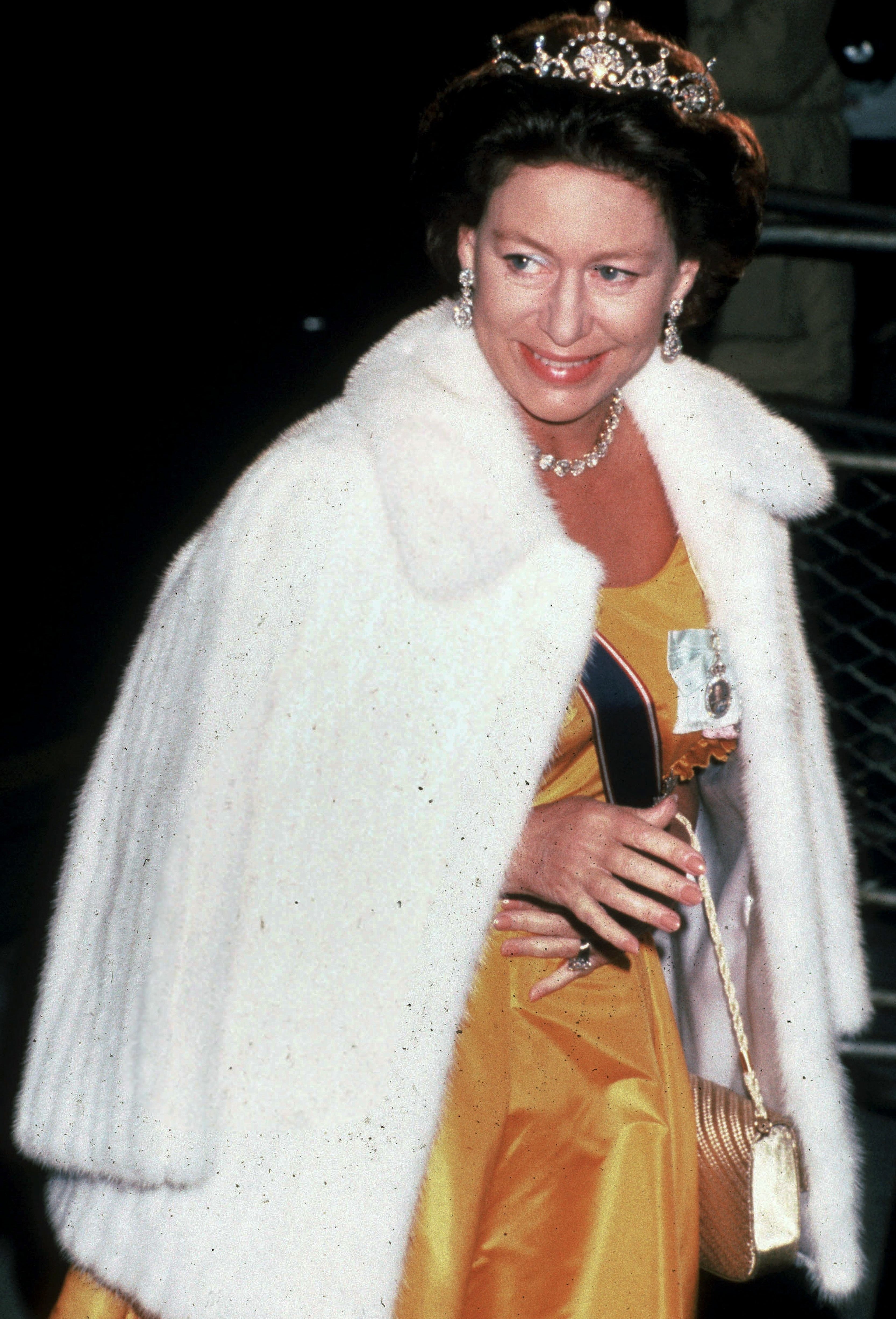 Close-up of Margaret smiling and wearing a crown and a fur jacket