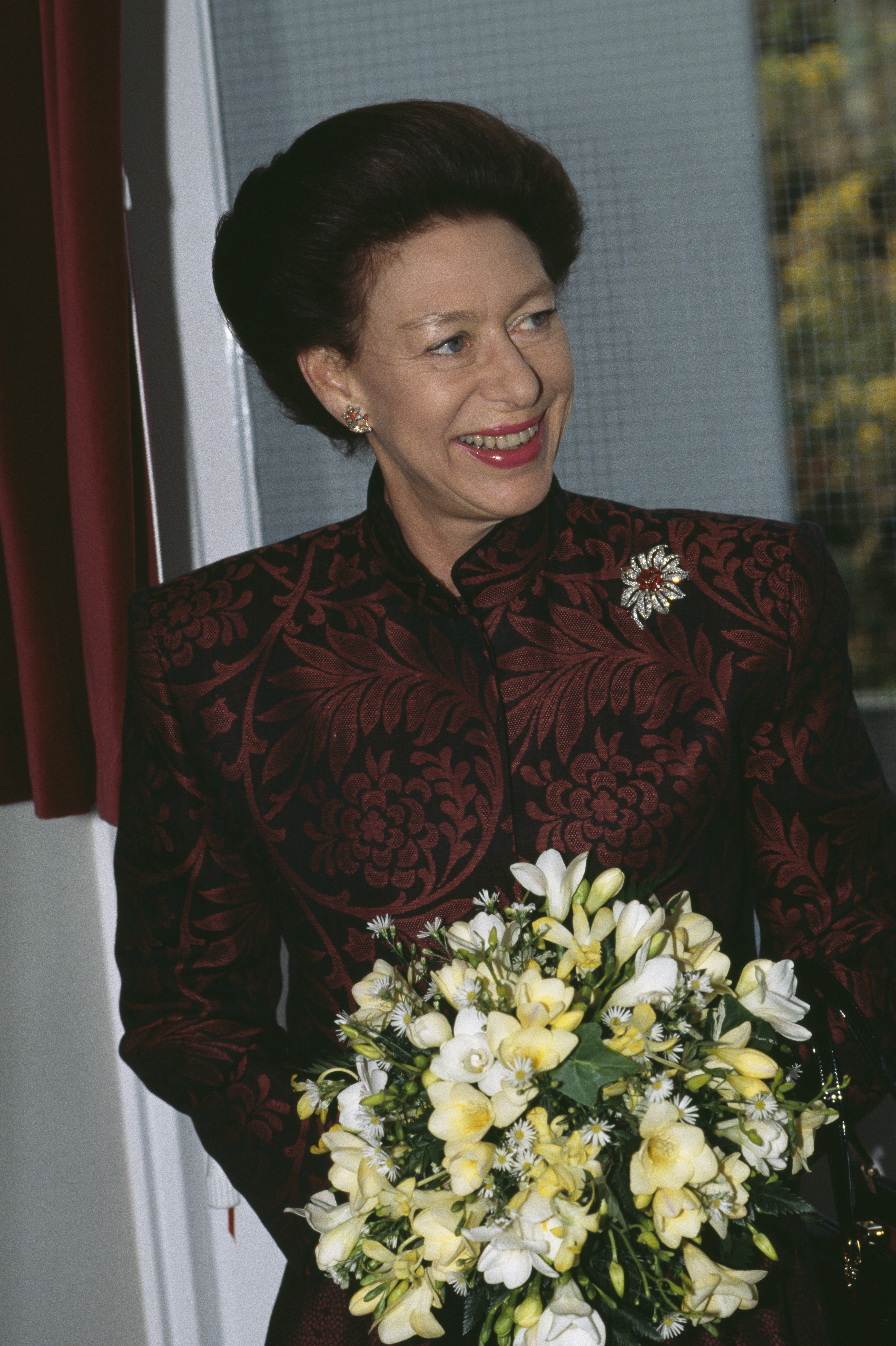 Close-up of Margaret holding flowers and smiling