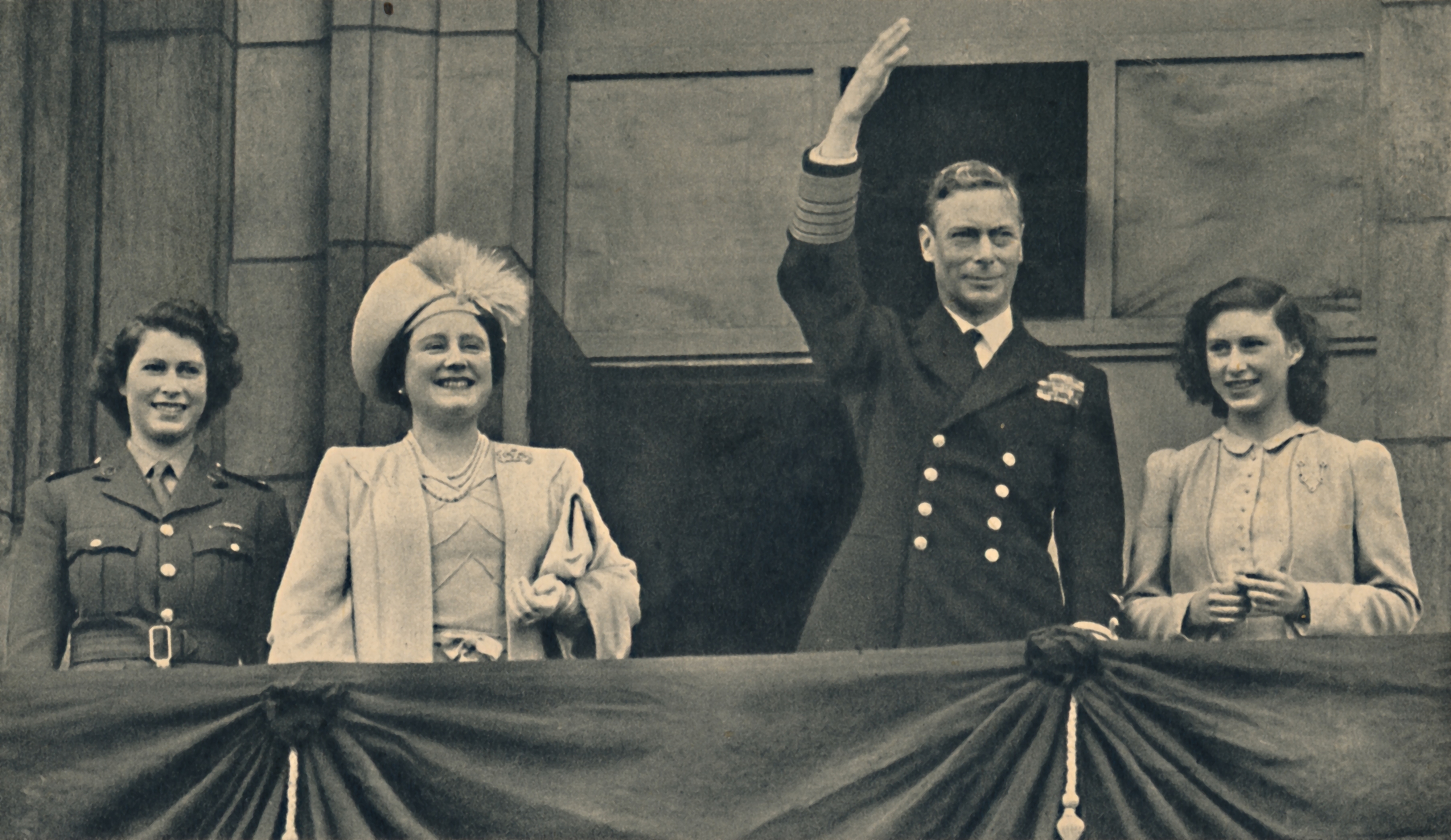 Elizabeth and Margaret on the balcony behind their parents, Queen Elizabeth, later the Queen Mother, and King George, who is waving