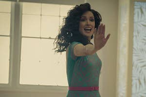 The actress Rose Byrne from the Apple TV show "Physical" wearing an 80s workout lycra outfit with her hand extended during an aerobics workout