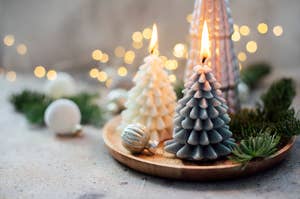 Two candles in the shape of Christmas trees. 