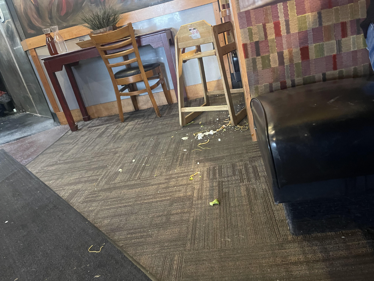 Food and waste all over the floor of a restaurant