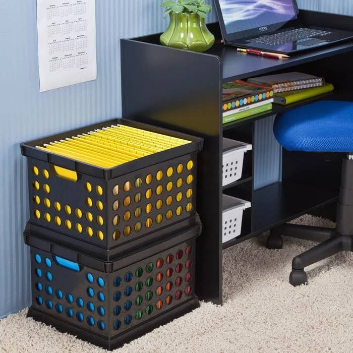 two black storage crates stacked in an office