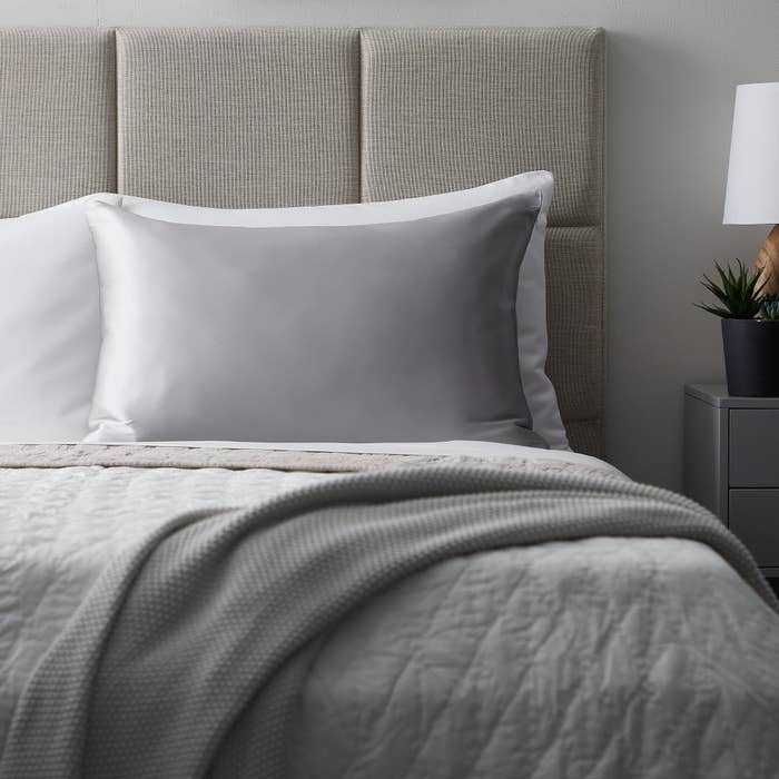 gray silk pillowcase on a bed