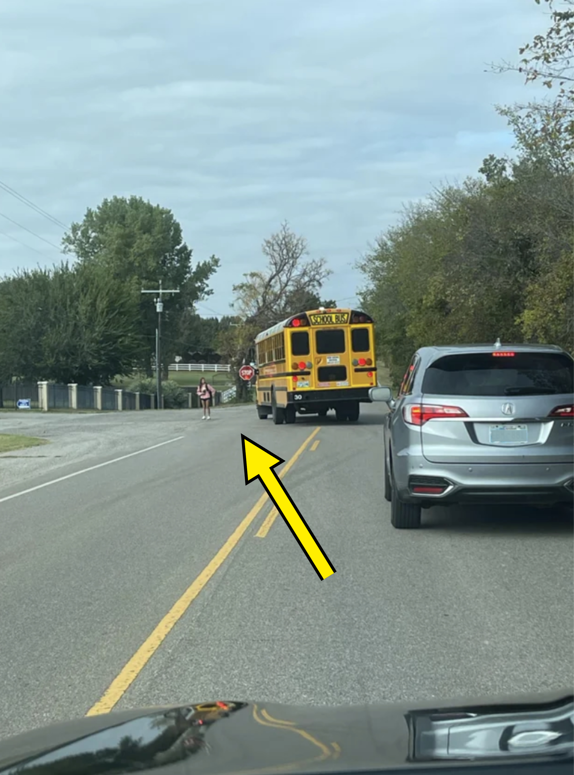 A bus pulled in the middle of the road to block traffic for kids that have to cross the street