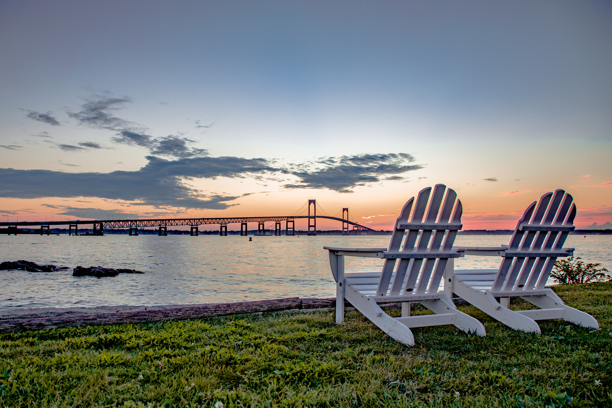 Empty chairs on beach against sky during sunset in Newport, Rhode Island