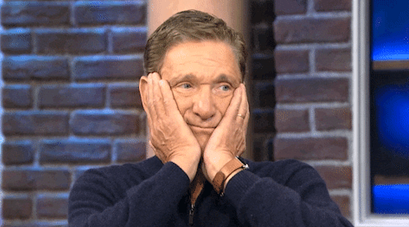 Maury Povich with his hands covering the sides of his face