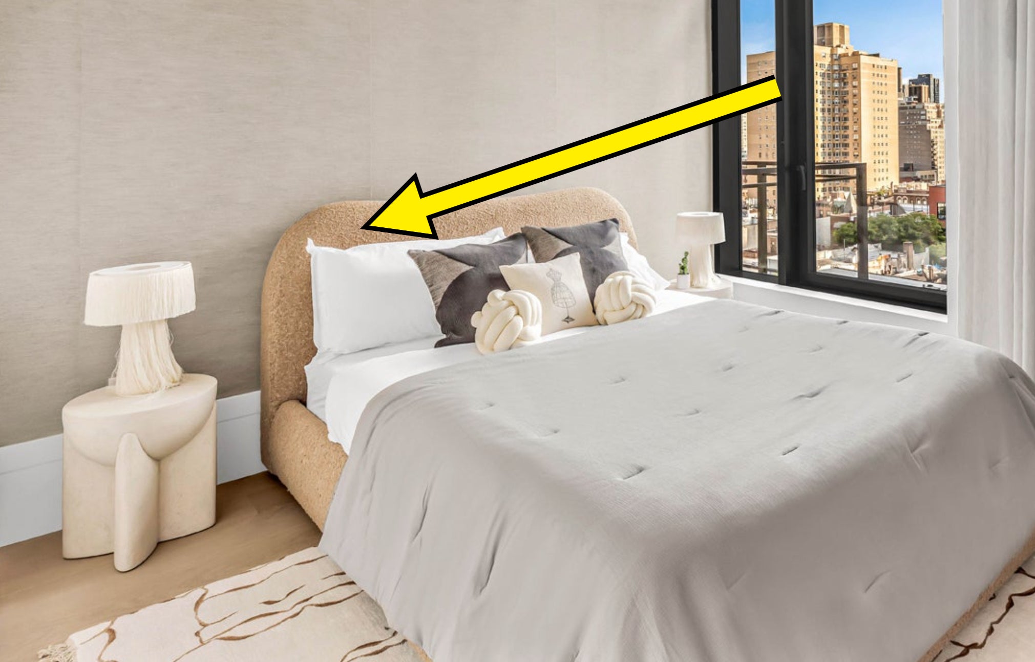 arrow pointing to a bouclé fabric bed in an apartment building