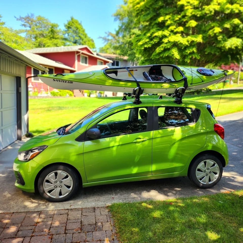 a small green car parked in a driveway