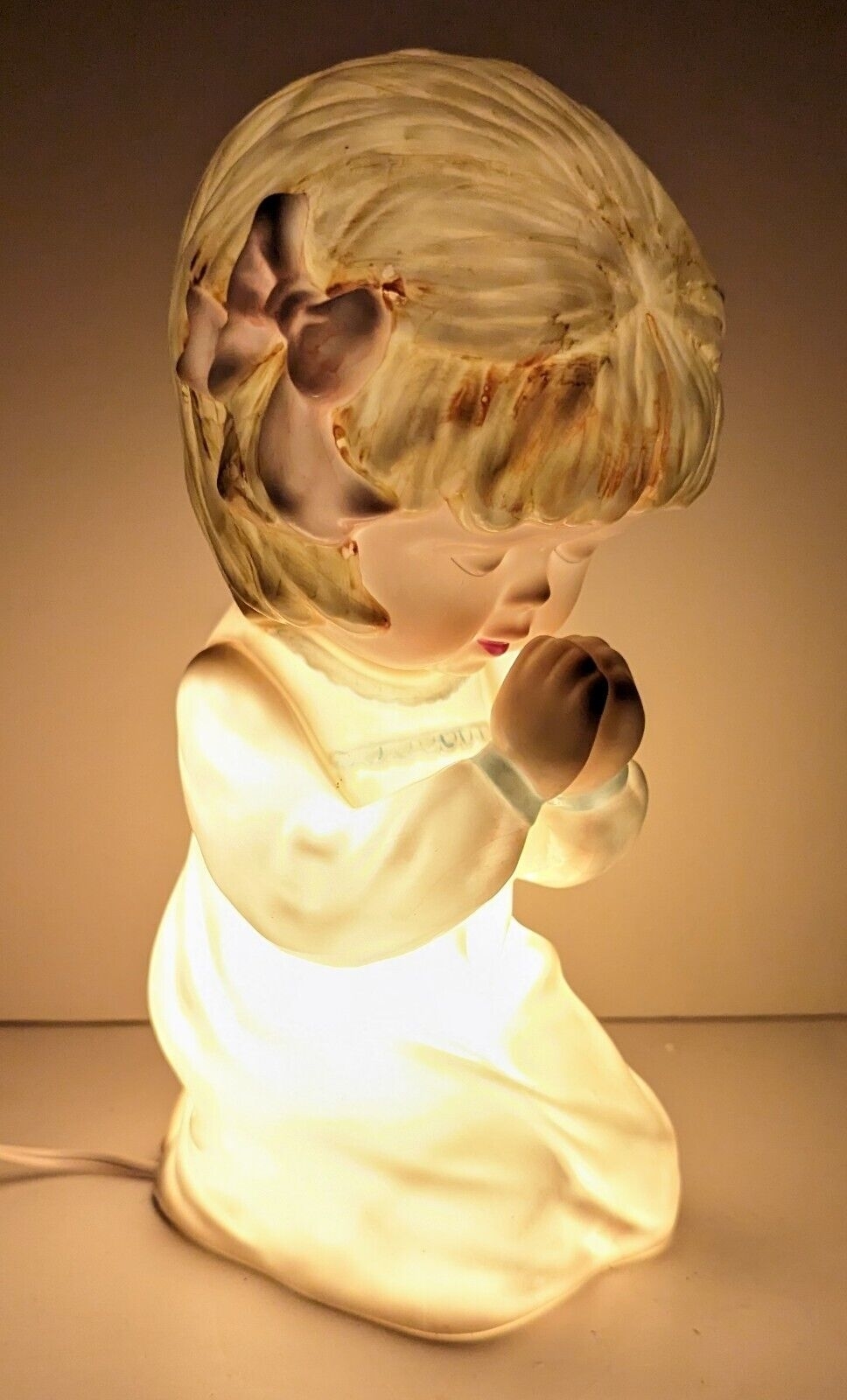 lit up ceramic lamp in the shape of a child praying