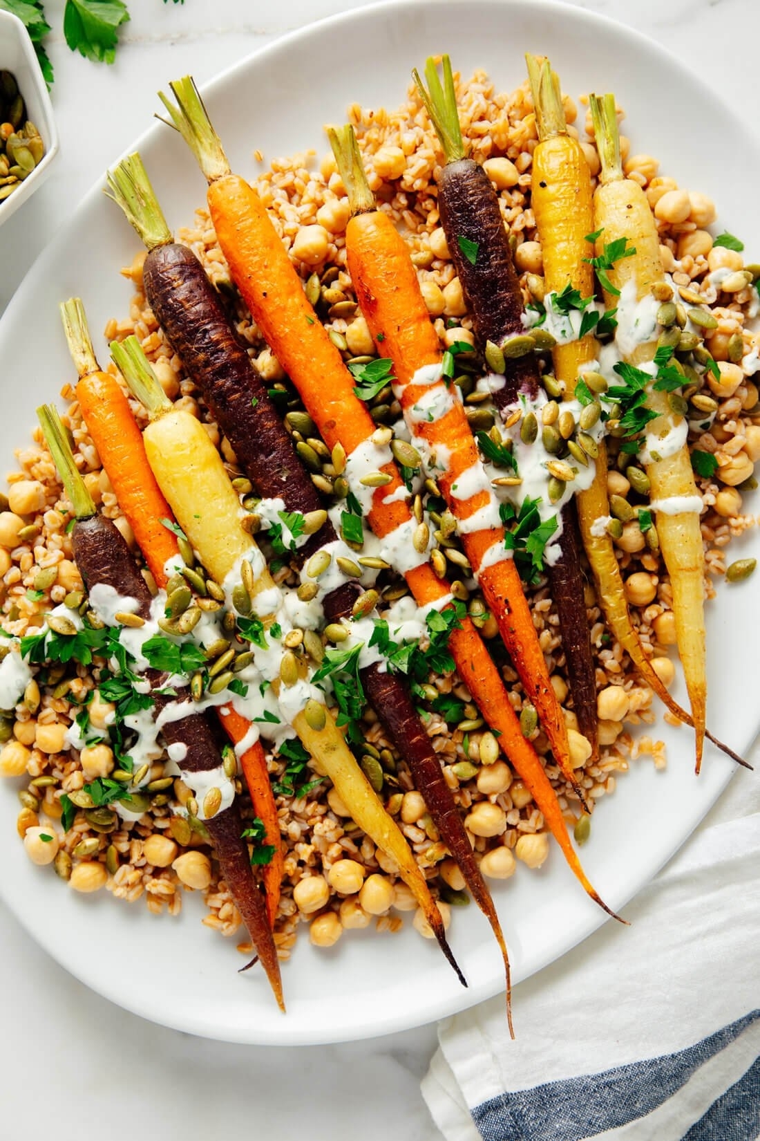 roasted rainbow carrots on a bed of farro and chickpeas