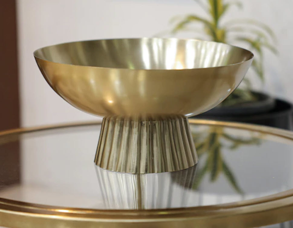 large gold accent bowl on top of glass gold table