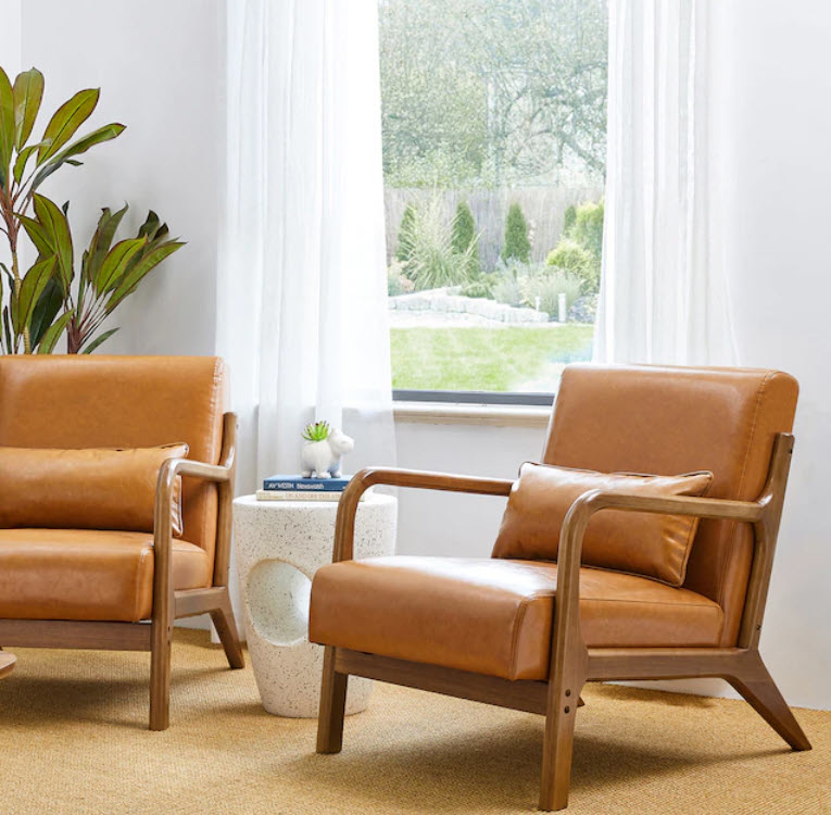 set of two faux leather accent chairs in living room space by window