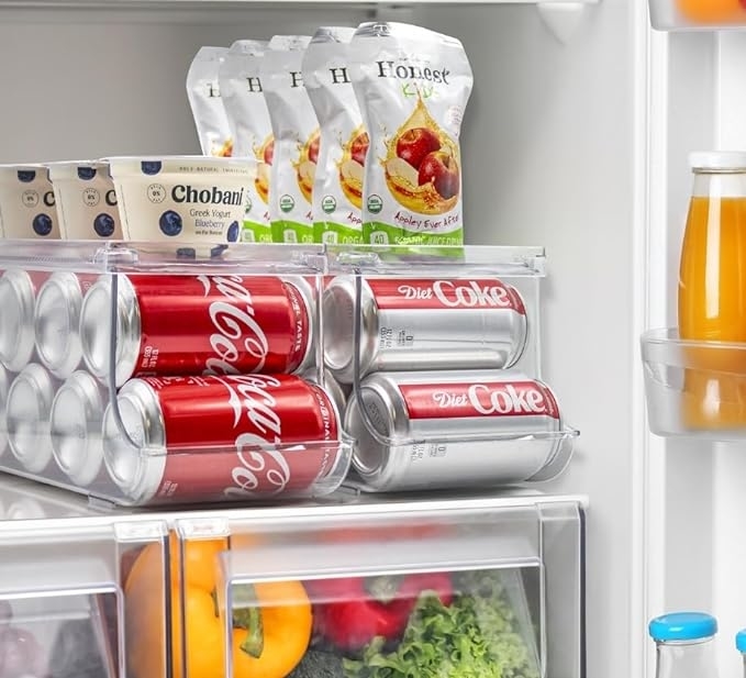 produce and cans of soda being stored in acrylic bins inside of a refrigerator