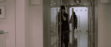 Andy from &quot;The Devil Wears Prada&quot; walking into her office in slow motion while flipping her hair