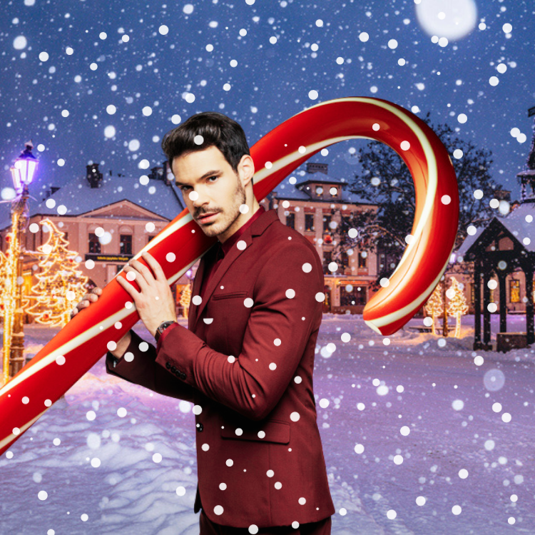 A man holding a giant candy cane