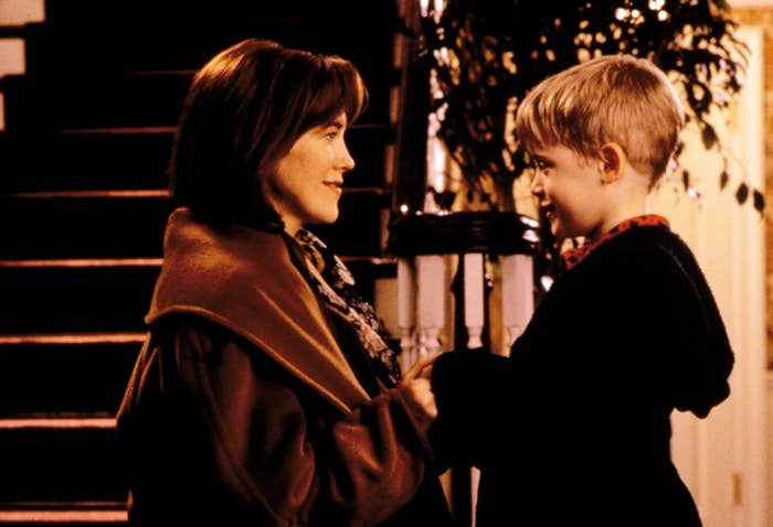Kate and Kevin McCallister smiling at each other by the stairs