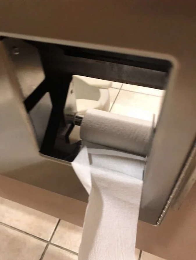 a hole in a bathroom stall