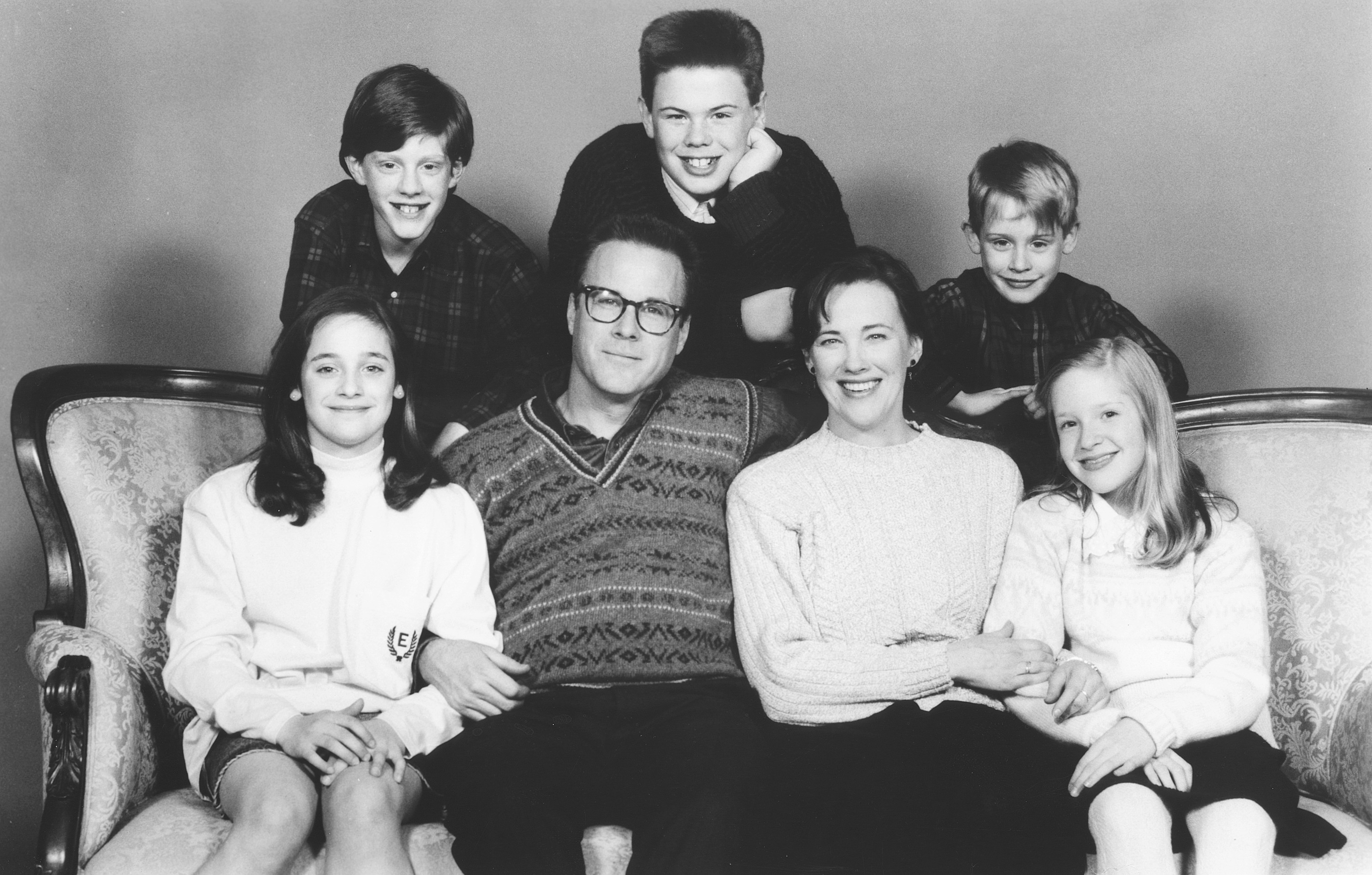 The McCallister family smiling on a couch