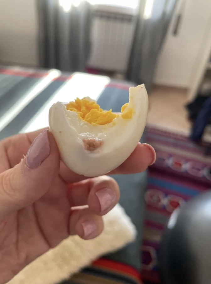 a piece of meat on a boiled egg