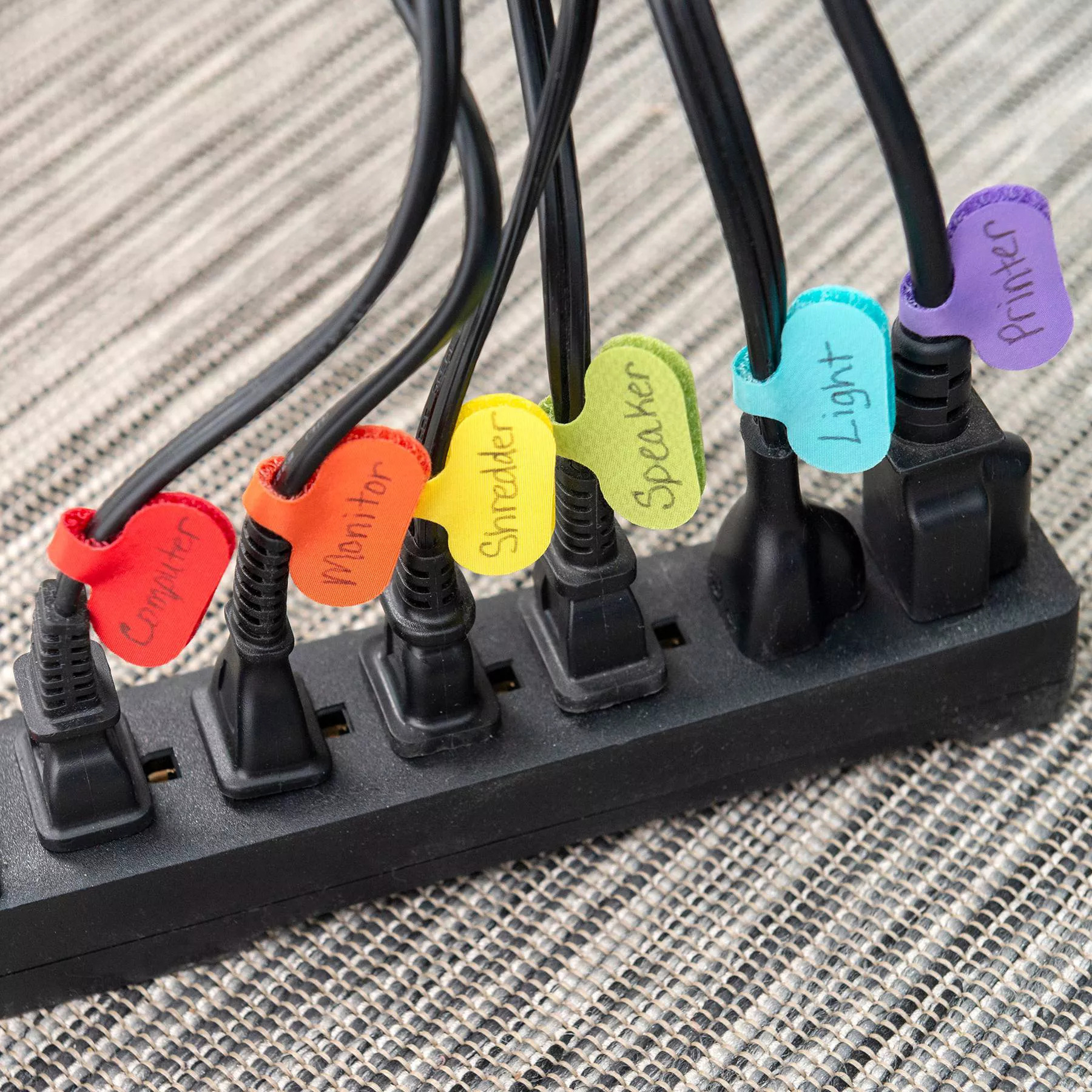tags affixed to six cables, each a different color with hand-written labels on them such as computer, monitor, speaker