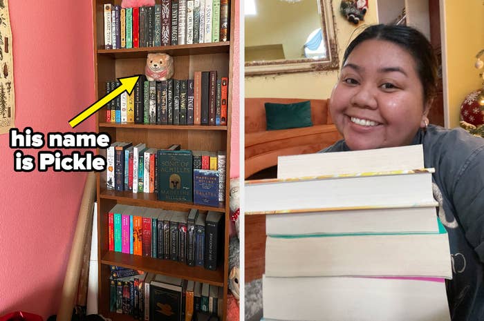 The author is showing off her bookcase and is posing with her books